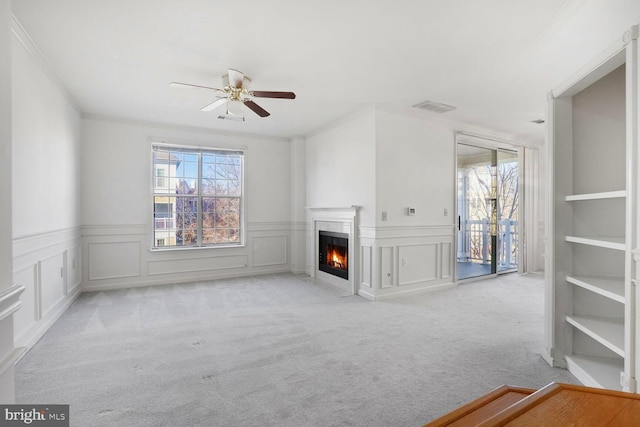 unfurnished living room with ceiling fan, light colored carpet, and ornamental molding