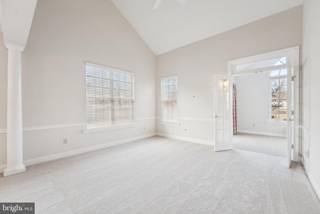 spare room with high vaulted ceiling, baseboards, light colored carpet, and ornate columns