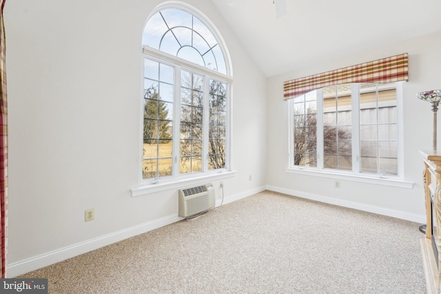 spare room featuring a wall mounted AC, carpet flooring, a wealth of natural light, and baseboards