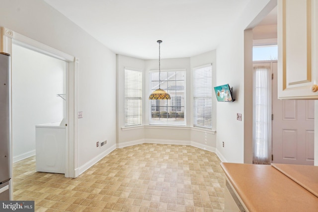 unfurnished dining area with baseboards