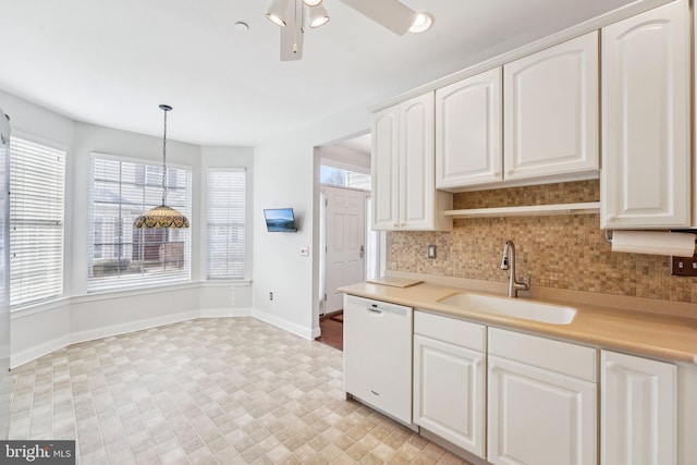 kitchen featuring white dishwasher, a sink, white cabinetry, hanging light fixtures, and light countertops