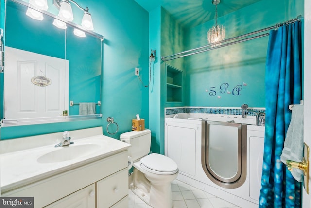 full bathroom with washer and dryer, vanity, toilet, and tile patterned floors