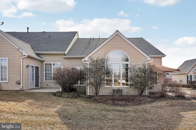 back of house featuring a patio area, a yard, and roof with shingles