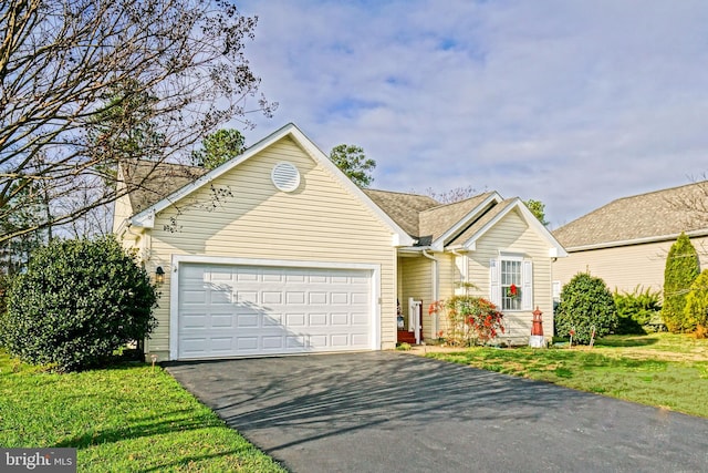 single story home with driveway, roof with shingles, an attached garage, and a front yard