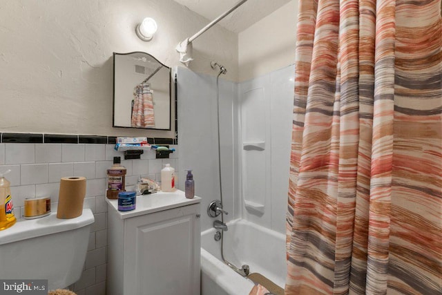 full bathroom with sink, tile walls, toilet, and shower / bath combination with curtain