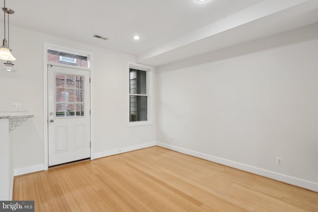 spare room with recessed lighting, visible vents, light wood-style flooring, and baseboards