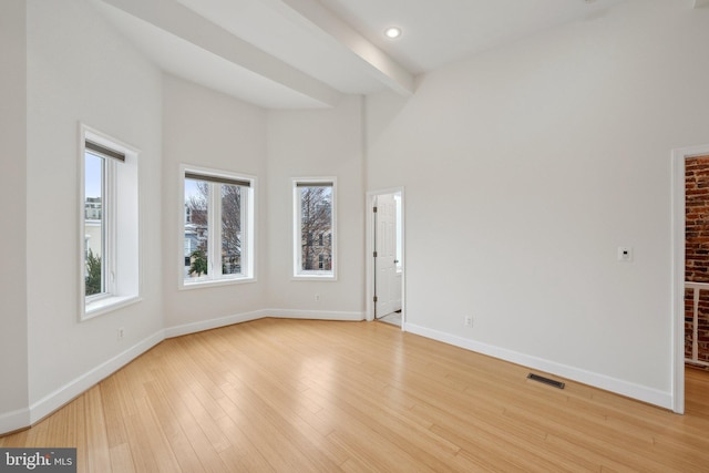 unfurnished living room featuring recessed lighting, a high ceiling, visible vents, baseboards, and light wood-style floors