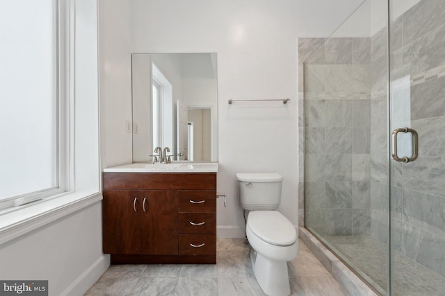 full bath with toilet, a stall shower, baseboards, and vanity