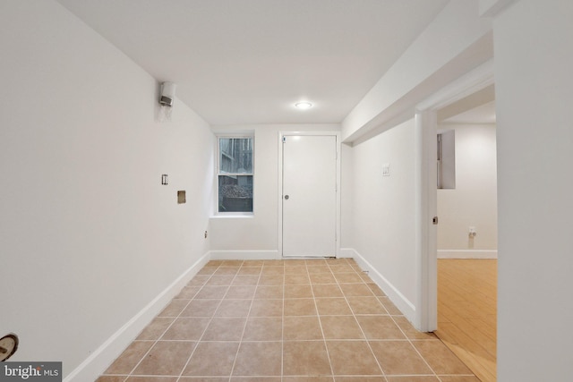 empty room featuring baseboards and light tile patterned flooring