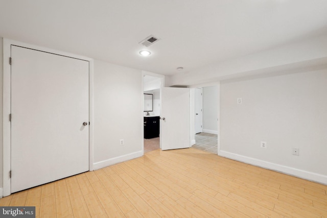 spare room with baseboards, visible vents, and wood finished floors