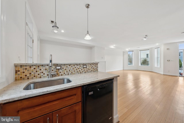 kitchen with light wood-style flooring, a sink, open floor plan, backsplash, and dishwasher