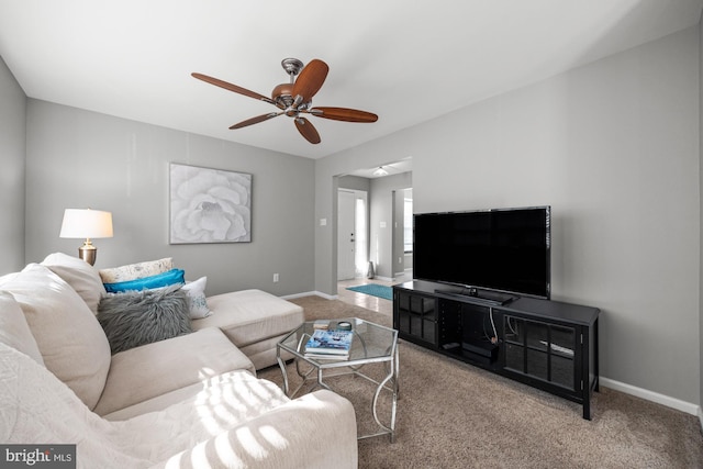 carpeted living room with ceiling fan