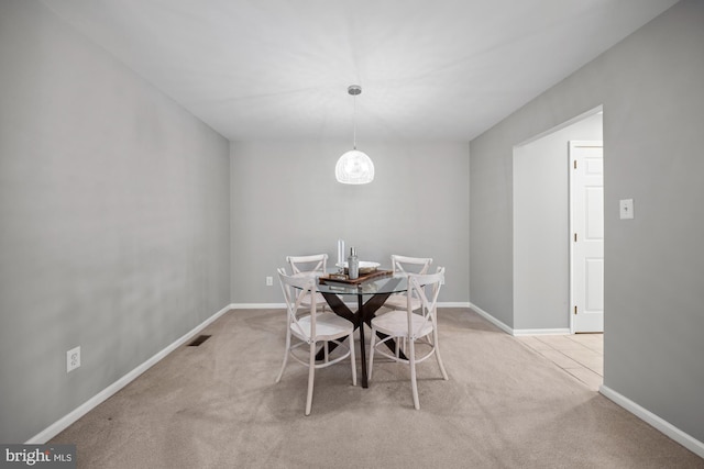 unfurnished dining area featuring an inviting chandelier and light colored carpet