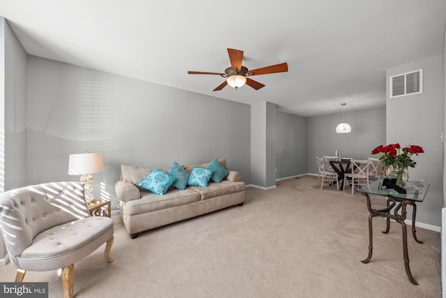 carpeted living room with ceiling fan