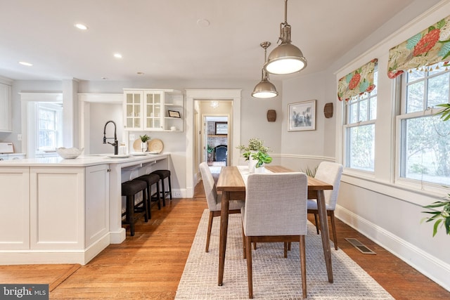 dining area with light wood-style floors, recessed lighting, visible vents, and baseboards