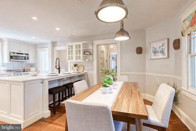 dining area featuring recessed lighting, plenty of natural light, light wood-style flooring, and baseboards