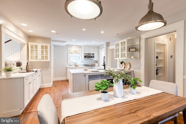 dining space featuring light wood-type flooring, baseboards, and recessed lighting