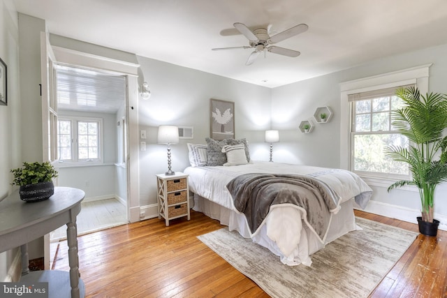 bedroom with light wood-style flooring, multiple windows, baseboards, and visible vents