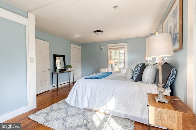 bedroom with baseboards and wood finished floors