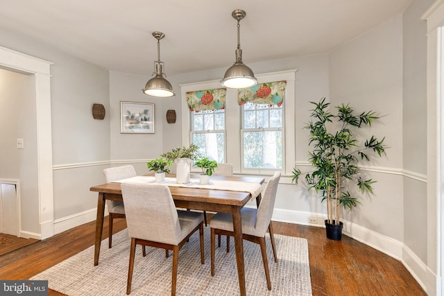 dining area with baseboards and wood finished floors