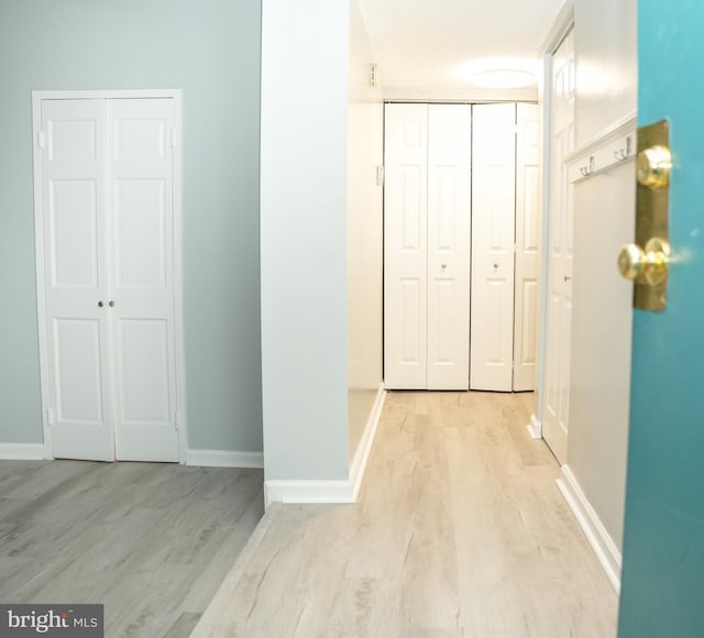 hall with light wood finished floors and baseboards