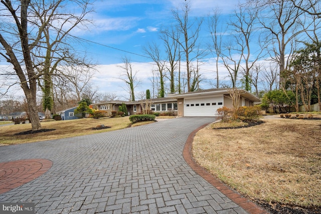 view of front of home featuring a garage, aphalt driveway, a front lawn, and stucco siding