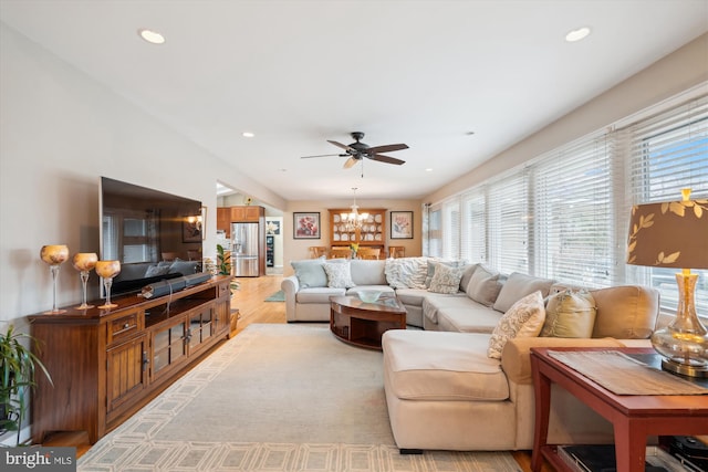 living area featuring ceiling fan with notable chandelier, light wood-style flooring, and recessed lighting