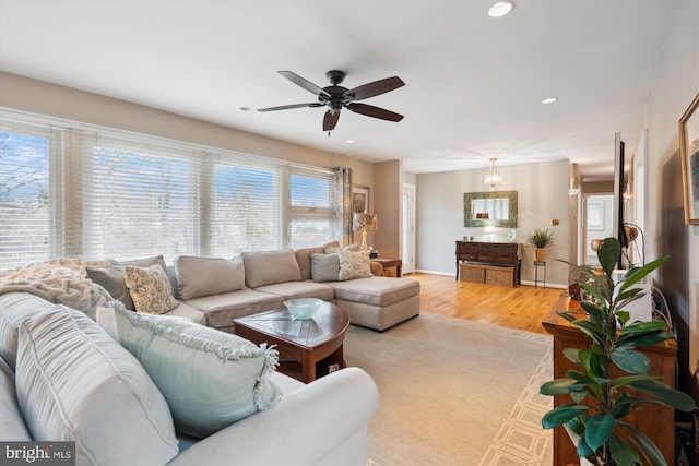 living room featuring light wood-type flooring, ceiling fan, baseboards, and recessed lighting