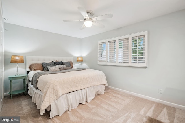 carpeted bedroom featuring ceiling fan and baseboards