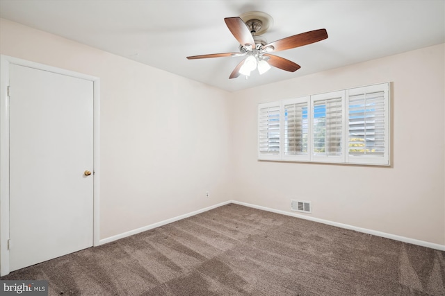 carpeted spare room featuring a ceiling fan, visible vents, and baseboards