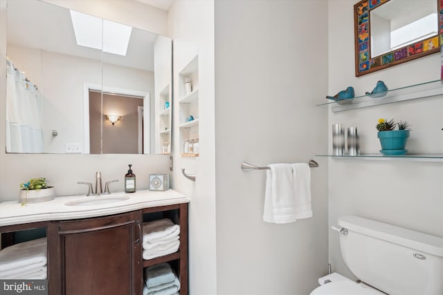 full bathroom with toilet, a skylight, and vanity