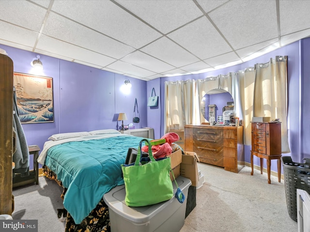 bedroom featuring a paneled ceiling, baseboards, and carpet flooring