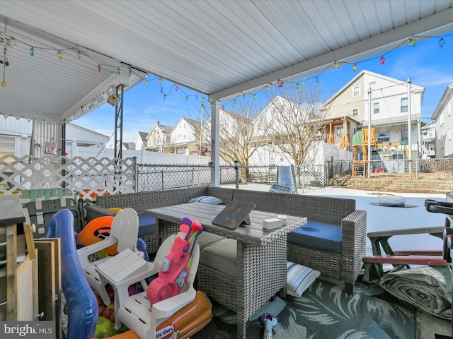 view of patio with an outdoor hangout area, fence, and a residential view