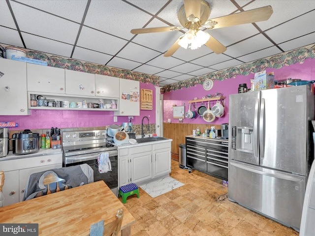 kitchen with a drop ceiling, stainless steel appliances, white cabinetry, open shelves, and a sink