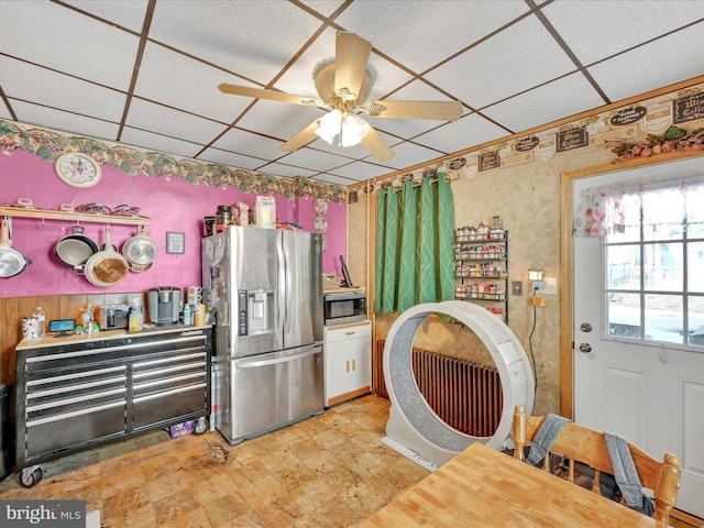 kitchen featuring ceiling fan, stainless steel appliances, and a drop ceiling