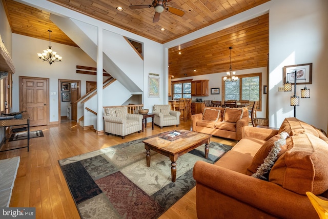 living room featuring stairway, light wood-style floors, high vaulted ceiling, wooden ceiling, and baseboards