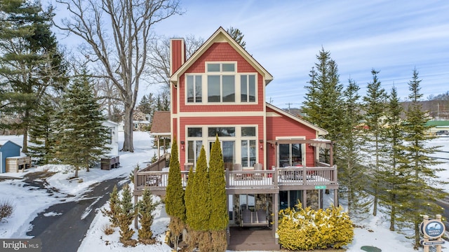 view of front facade featuring a chimney and a wooden deck