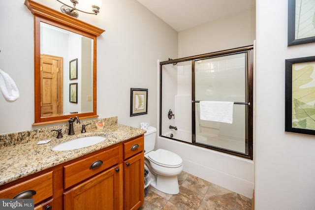 bathroom featuring toilet, shower / bath combination with glass door, and vanity