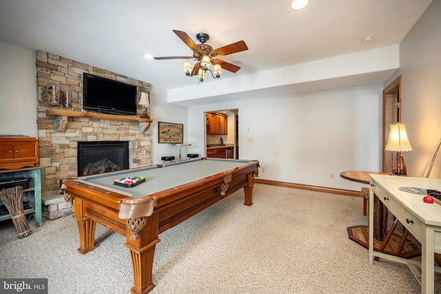 rec room with baseboards, light colored carpet, ceiling fan, a stone fireplace, and recessed lighting