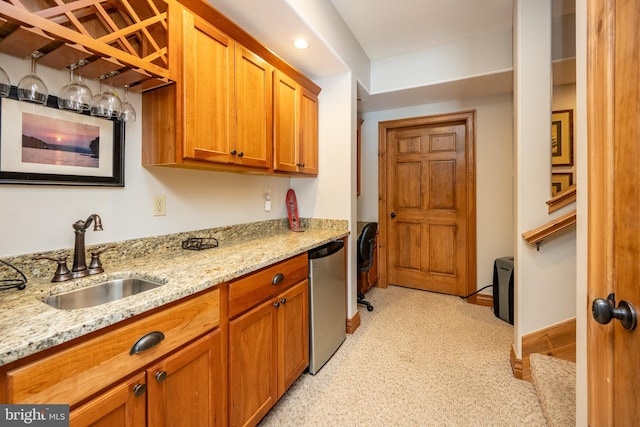 kitchen featuring dishwasher, baseboards, light stone counters, and a sink