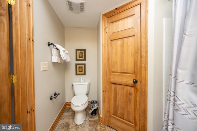 bathroom featuring toilet, baseboards, and visible vents