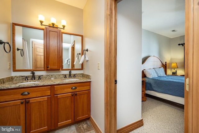 ensuite bathroom featuring baseboards, visible vents, a sink, and ensuite bathroom