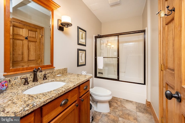 bathroom with baseboards, vanity, toilet, and bath / shower combo with glass door