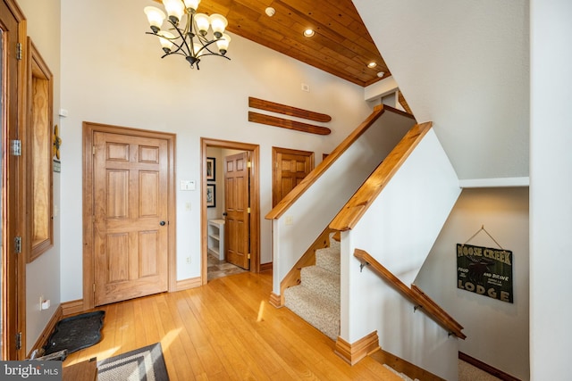 foyer featuring a high ceiling, baseboards, stairway, and light wood finished floors