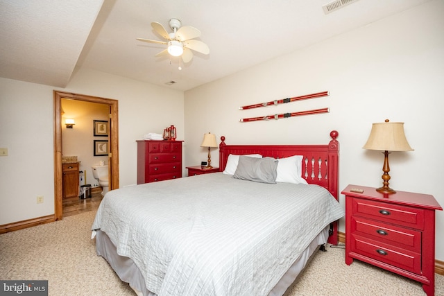 bedroom featuring visible vents, light carpet, ceiling fan, ensuite bath, and baseboards