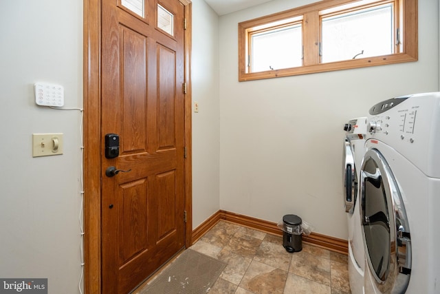 washroom with laundry area, baseboards, and separate washer and dryer