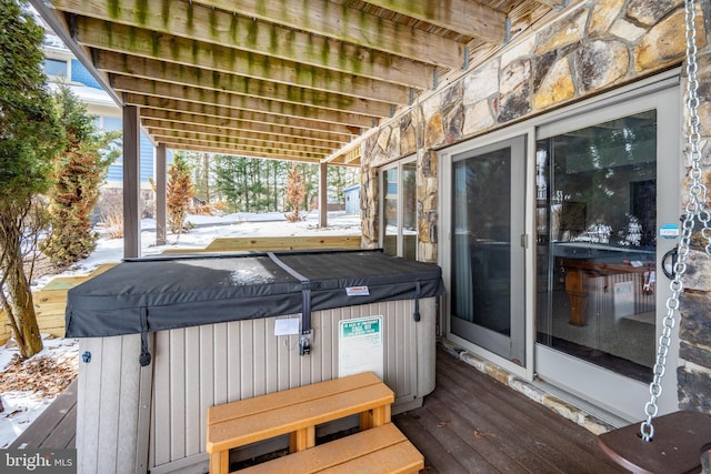 snow covered deck featuring a hot tub