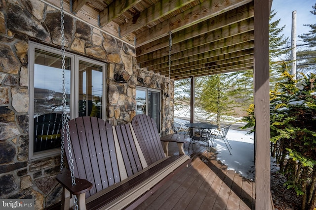 snow covered deck featuring outdoor dining area