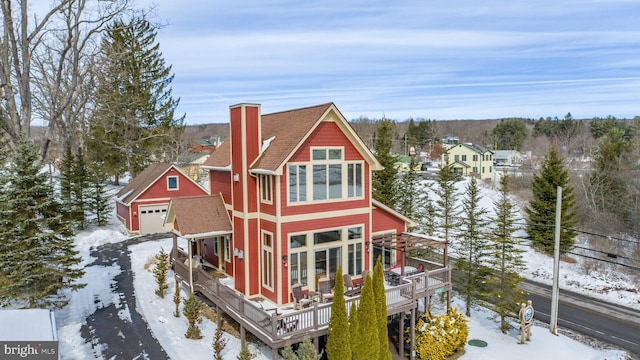 exterior space featuring a detached garage, an outbuilding, and a wooden deck