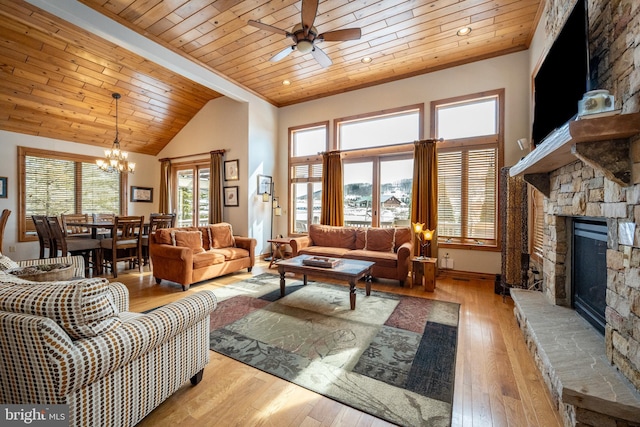 living area with a fireplace, light wood-style floors, wooden ceiling, baseboards, and ceiling fan with notable chandelier